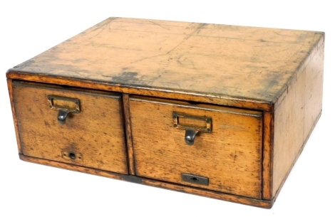 An early 20thC oak index chest of two long drawers, 18cm high, 48cm wide, 39cm deep.