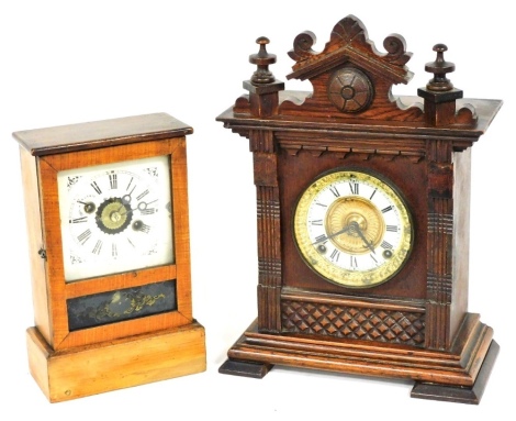 A late 19thC American pine cased mantel clock, with a tin dial bearing Roman numerals, the movement with alarm bell function, 27cm high, and an Ansonia oak cased mantel clock, circular enamel dial bearing Roman numerals, eight day movement with coiled gon