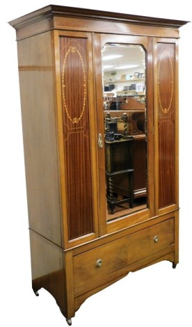 An Edwardian mahogany and marquetry wardrobe, with a moulded cornice above a bevelled mirror plate to the door and a further plinth drawer, on bracket feet with metal castors, 210cm high, 138cm wide.