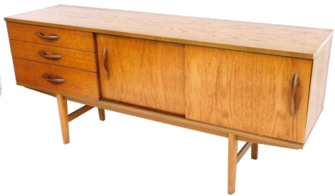 A 1960/70's teak sideboard, with an arrangement of three drawers, two sliding doors on rounded tapering legs, 71cm high, 165cm wide, 43cm deep.