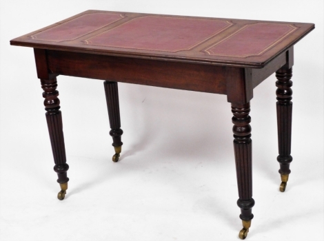 A Victorian style mahogany library table, with a gilt and red leather inset top, on turned and fluted legs, brass capped on castors, 75.5cm high, 114cm wide, 57cm deep.