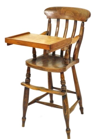 A 19thC ash and elm child's lath back high chair, with shaped arms, turned supports and later tray.