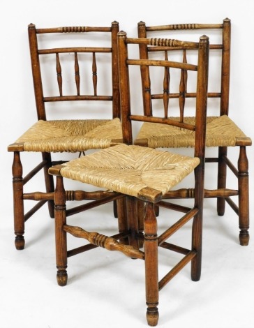 A set of three 19thC oak and rush seated country chairs, raised on turned legs united by a double box stretcher.