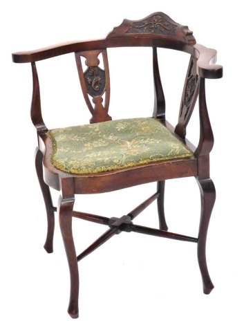 An Edwardian walnut corner chair, with a carved crest, pierced and shield carved splat, a padded seat, on cabriole legs with X shaped stretcher.