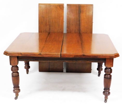 A Victorian walnut extending dining table, with two additional leaves, on turned and fluted legs, brass capped on castors, 91cm high, 144cm wide, 231cm extended, 117cm deep.