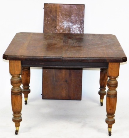 A Victorian walnut extending dining table, with one additional leaf, on turned and fluted legs, brass capped on castors, 71cm high, 89cm wide, 140cm extended, 100cm deep.