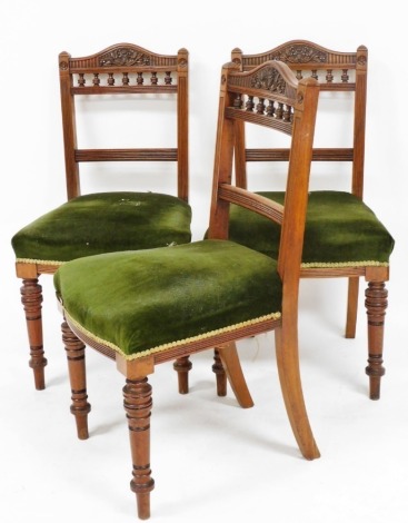 A set of three Victorian walnut single dining chairs, with overstuffed seats, raised on turned legs.