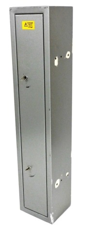 A silver painted metal gun cabinet, the door with two locks enclosing divisions for four guns and a shelf, 153cm high, 31cm wide, 28cm deep.