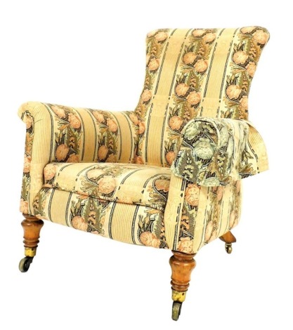 A Victorian walnut armchair, upholstered in floral fabric decorated with columns, on turned legs with castors.