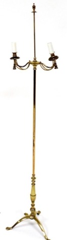 A brass two branch floor lamp, decorated with tassels on a tripod base, 159cm high.