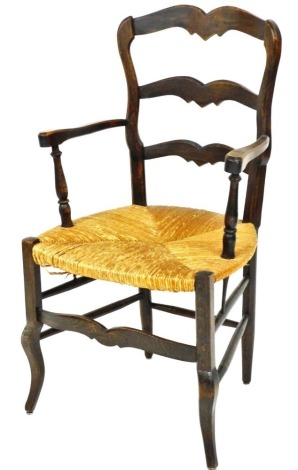 A 19thC French beech ladderback open armchair, with a rush seat on shaped legs.