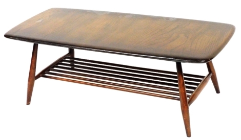 An Ercol elm coffee table, the rectangular top with rounded corners, on turned supports with slatted magazine rack, 35cm high, 100cm wide, 44cm deep.