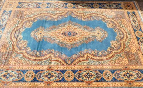 A Belgian wool machine woven Keshan Super carpet, with a central elongated medallion in gold on a blue ground, 300cm x 478cm.