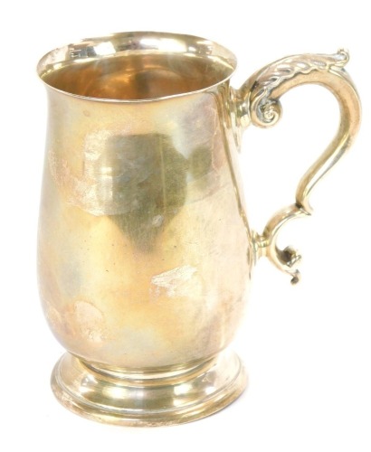 An Elizabeth II silver tankard, of plain form with acanthus leaf scroll handle, on a stepped foot, Birmingham 1960, 18cm high, 10½oz.