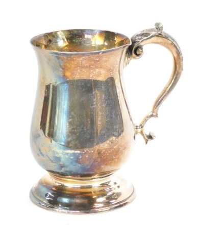 An Elizabeth II silver tankard, of plain form with acanthus leaf scroll handle on a stepped foot, maker BD, Sheffield 1967, 15cm high, 9½oz. (AF)