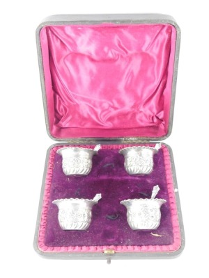 A set of George V silver salts and spoons, each with a flared rim and embossed floral design, London 1924, comprising four bowls and four spoons, in fitted case, 2¾oz. - 3