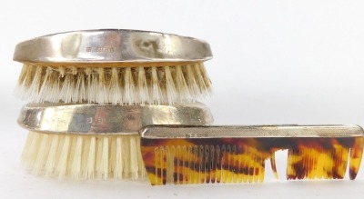 An Elizabeth II silver travel dressing table set, comprising two brushes and comb, the brushes with engine turned decoration with vacant crest, the comb with imitation tortoiseshell, Birmingham 1972. - 2