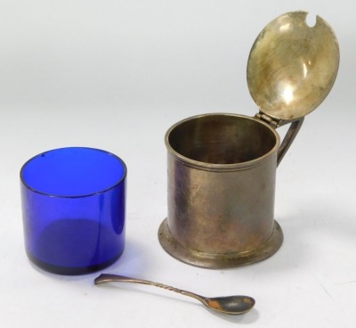 A Victorian silver mustard pot, with a shaped thumb piece clasp on plain body with a buckle crest, London 1889, with a later spoon and blue glass liner, 4½oz. - 2