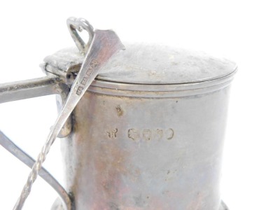 A Victorian silver mustard pot, with a shaped thumb piece clasp on plain body with a buckle crest, London 1889, with a later spoon and blue glass liner, 4½oz. - 3