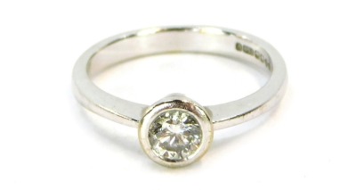 An 18ct white gold diamond solitaire ring, with round brilliant cut diamond approximately 0.50ct, in a rub over setting on a plain band, ring size N, 4.1g all in.