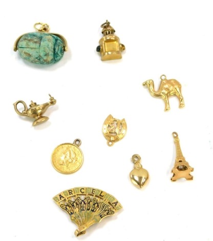 A group of 9ct gold and other charms, comprising a swivel scarab beetle, love heart, Aladdin's lamp, thirteen in horseshoe, enamelled fan, Eiffel tower, camel, miner's lamp and a one dollar, 14.4g all in.