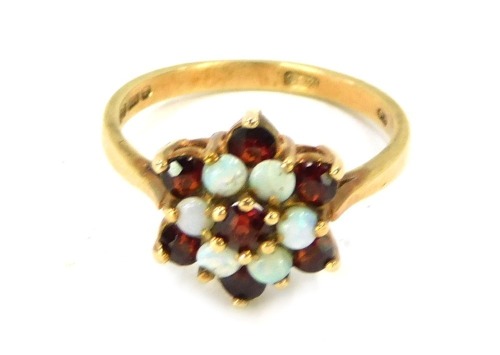 A 9ct gold cluster ring, set with layers of garnets and opals in a raised basket, size N, 2.7g all in.