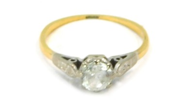 A dress ring, with central imitation diamond paste stone and platinum set shoulders on a thin band, yellow metal unmarked, size N½, 2.4g all in.