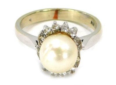 A dress ring with central cultured pearl, surrounded by round brilliant cut tiny diamonds, on a white gold band, stamped 750, size M, 4.7g all in.