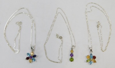 Three silver multi stone set necklaces, comprising two cluster pendants formed as flowers, and a three drop pendant, each on box link white metal chain, stamped 925, 44cm long, 15g all in. (3) - 2