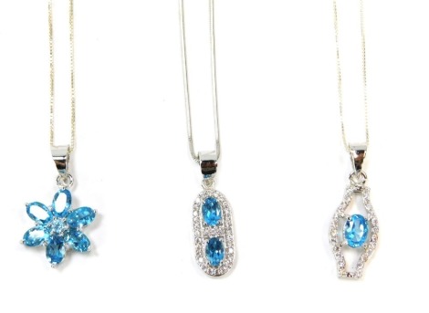 Three blue zircon and silver pendants and chains, comprising a six point cluster pendant, an Art Deco style two blue zircon set pendant and a further example, one on articulated chain, the others on fine link chains, 44cm long, 13.3g all in. (3)