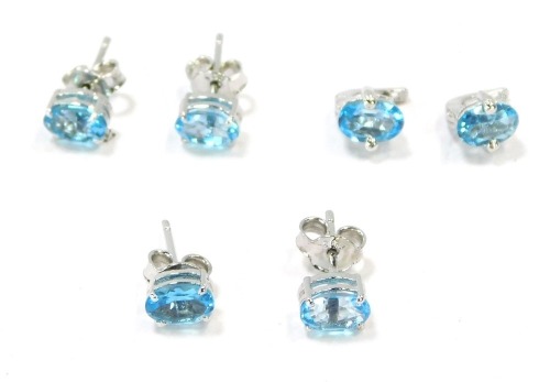 Three pairs of silver and blue zircon set studs, comprising two oval plain studs and a pair of half hoop backed studs, 4.7g all in. (3)