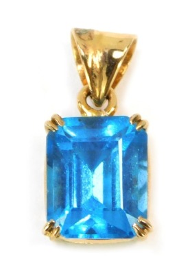 A blue zircon rectangular pendant, the square cut stone in double four claw setting, in a raised yellow metal basket, stamped 18k to pendant loop, 2cm high, 2.9g all in.