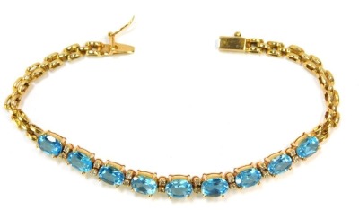 A blue zircon and diamond set line bracelet, set with nine oval cut blue zircons and twelve tiny diamonds, in yellow metal stamped 750, 18cm long, 14.7g all in.