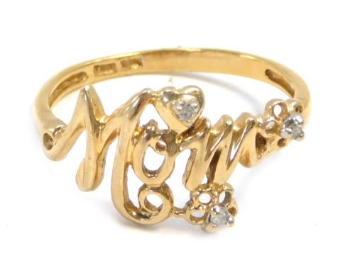 A Mum dress ring, bearing the inscription Mum, with hearts and flowers, set with tiny white stones, stamped TRK 18K to band, size Q, 1.8g all in.