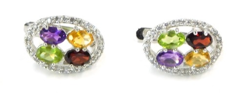 A pair of silver multi stone cluster earrings, the oval earring with outer CZ border and a red green yellow and purple stone set centre, 5.7g all in.