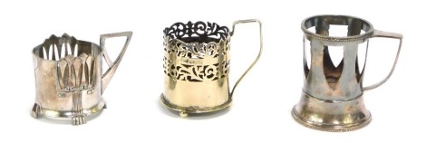 A 20thC WMF Art Nouveau pewter cup holder, partially pierced with angular handle on shaped paw feet, impressed marks beneath, 9cm high, and two others similar. (3)