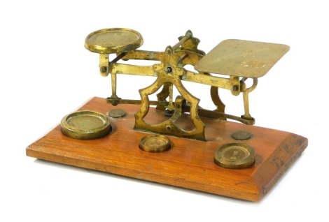 A 20thC brass Criterion table postal scale on oak base, with removable weights.