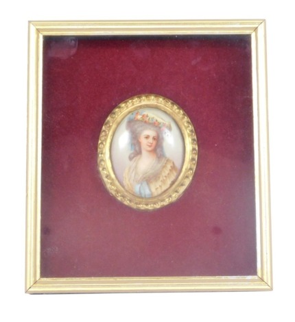 A framed porcelain portrait miniature, of a female with grey flowing hair in a yellow and rose detailed dress, in a gilt portrait frame in a rectangular cushioned red velvet frame, unsigned, the portrait 7.5cm x 6.5cm, the frame 23.5cm x 21cm.