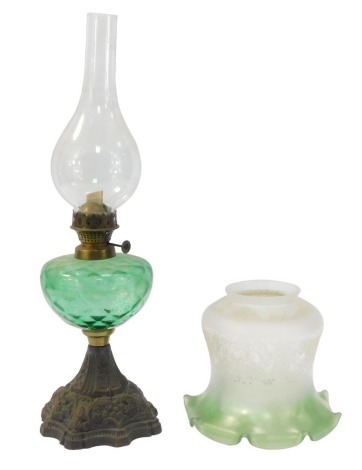 An early 20thC oil lamp, with frosted, clear and green glass shade, textured green glass reservoir and metal stem, with plain funnel marked Griffin Brand, 51cm high.