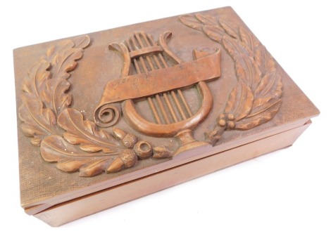 A Hungarian carved wooden box, the lid decorated with a wreath and a lyre, inscribed Asarka Di Biblia Kor Csatho Gyulanak 1927, the interior of the lid, with incised carving of a monkey smoking a pipe, picked out in colours, 30cm wide.