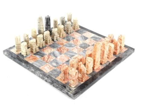 An alabaster chess set, with board, set with coloured pieces, 36cm wide.