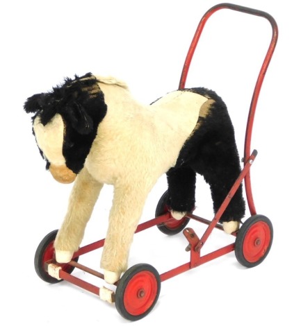 A vintage child's push-a-long horse, red metal frame, 51cm high, 52cm wide.