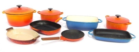 Le Crueset wares, comprising three orange casserole dishes and lids, 30cm, 23cm and 25cm diameter, a blue rectangular casserole dish, 20cm wide, and three orange grill pans. (7)