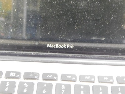 An Apple Mac Book Pro, with charger cable. - 2