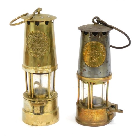 Two miner's lamps, each with badge for The Protector Lamp & Lighting Company, each stamped Eccles, one number 123, 24cm high and 22cm high (2)