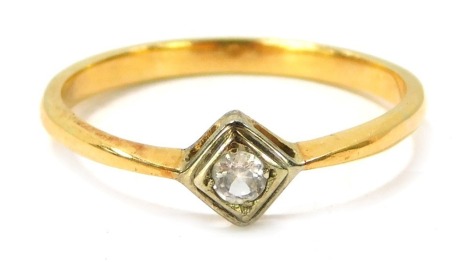 A diamond dress ring, the central diamond shaped rub over setting, with round brilliant cut diamond, in platinum, on a yellow metal plain band, unmarked, size R½, 2.5g all in.