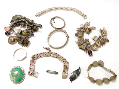 A group of silver and other jewellery, comprising silver and green enamel oval brooch, two silver charm bracelets, bangles, bark effect bracelet, etc. (a quantity)