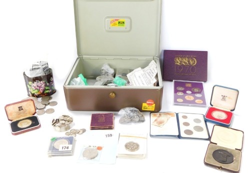 A group of coins and commemorative packs, to include 6th February 1977 coin, crowns, threepenny bits, Churchill commemorative crowns, First Decimal Coin set, pound coins, etc. (1 tin)