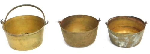 Three graduated Victorian swing handle preserve pans, largest 28cm diameter. (3)
