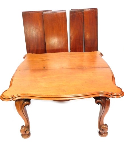 A Victorian mahogany extending dining table, with fluted and moulded two layered corners, on cabriole legs, terminating in castors, with four additional leaves, 75cm high, 132cm wide, 148cm deep, with additional leaves 60cm, 46cm, and two 27cm.